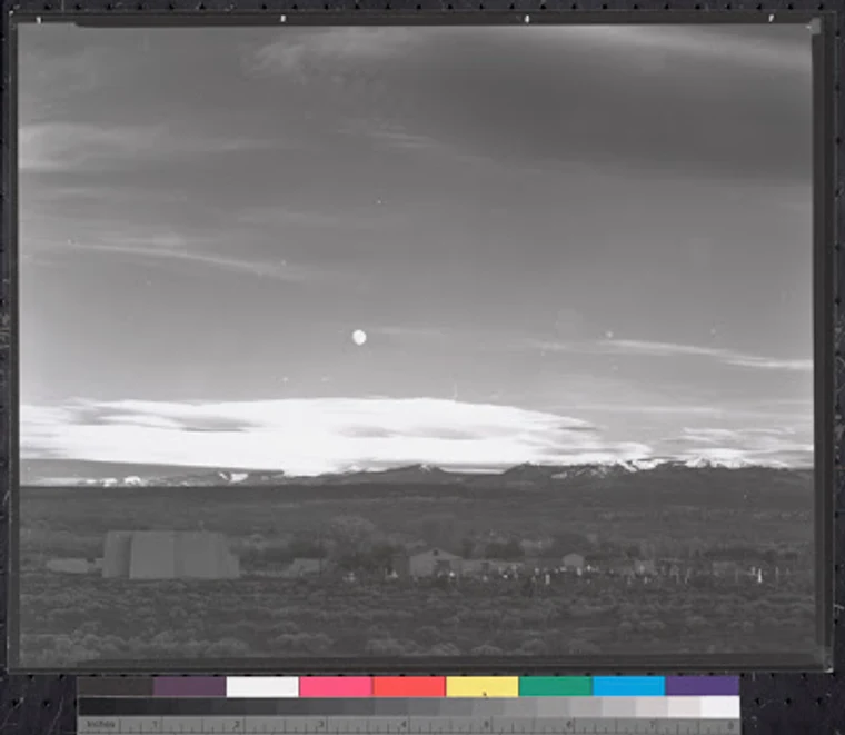 A flat, gray scan of the original Moonrise negative with a color reference strip, far less dramatic than the final print.