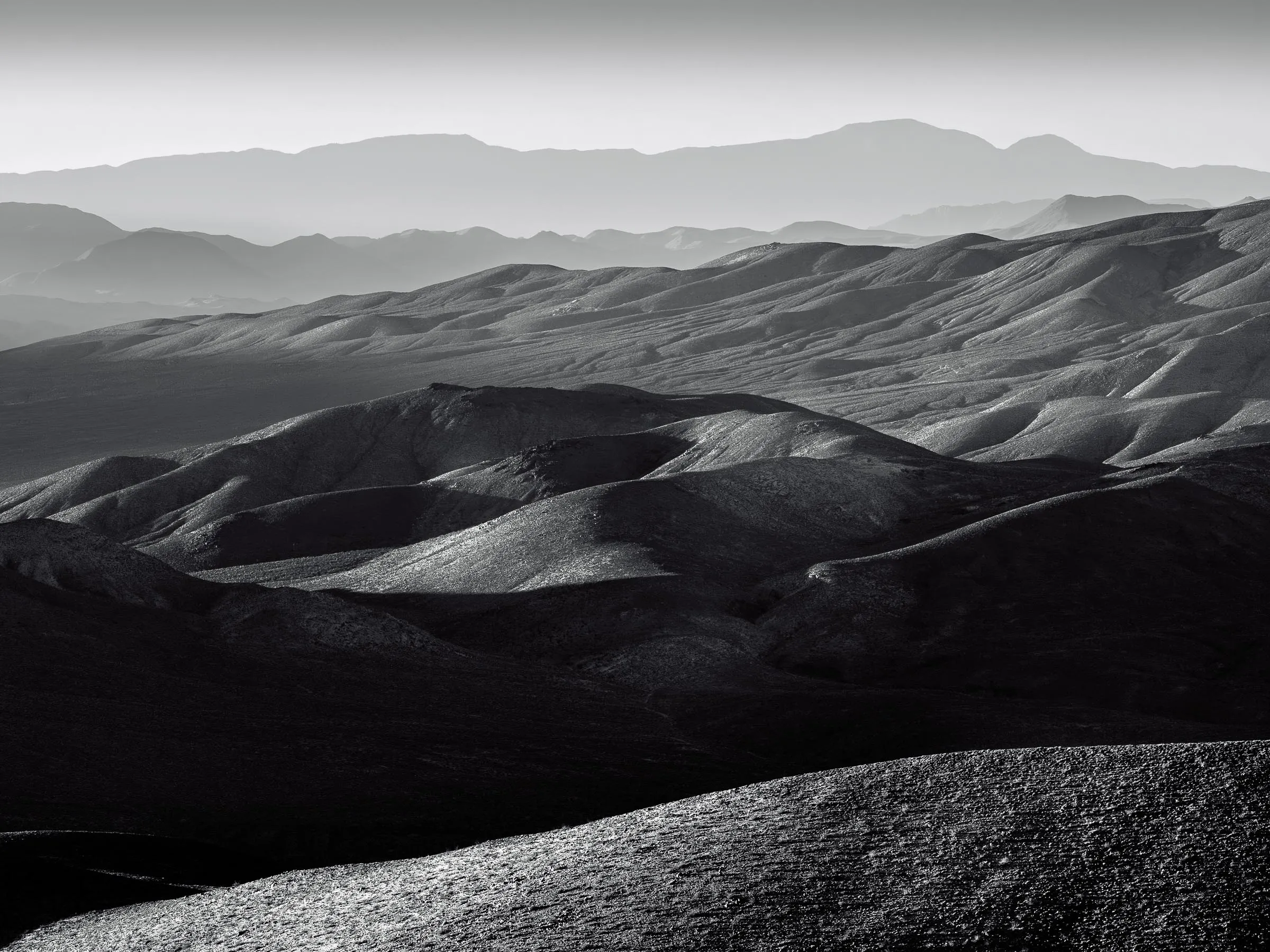 Layered desert ridgelines in black and white, a study in line and shape