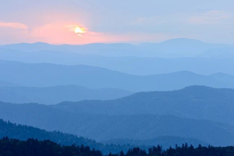 Layered blue mountain ridges receding into atmospheric haze, each ridge a paler form than the last.